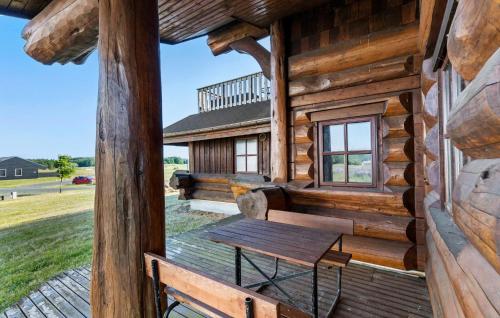 a bench on the porch of a log cabin at Stunning Home In Nimtofte With Kitchen in Nimtofte
