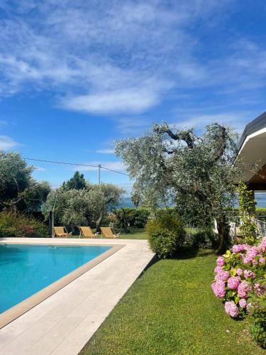 a yard with a swimming pool and some flowers at Villa Cà Brusà in Bardolino