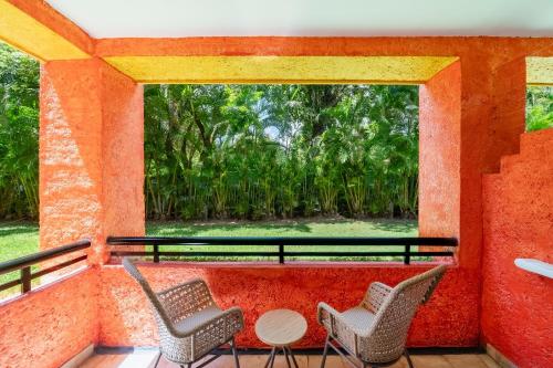two chairs and a table on a balcony with a window at Iberostar Waves Tucan - All Inclusive in Playa del Carmen
