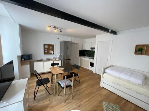 un salon avec une table et des chaises et une cuisine dans l'établissement Studio centre ville, à La Rochelle