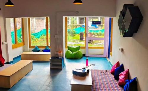 a living room with a couch and colorful pillows at Oak Land House in Manāli