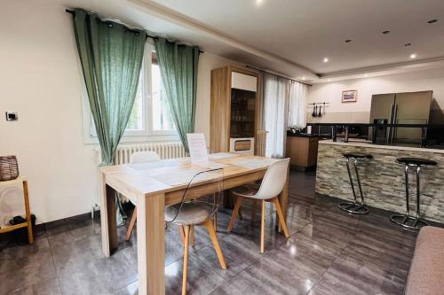 une salle à manger avec une table et des chaises en bois dans l'établissement Appartement Proche centre ville avec Parking Gratuit, à Annecy