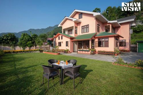a house with a table and chairs in the yard at StayVista at Thangsing Farmhouse 4 BHK Pahadi villa with Gazebo, Indoor-Outdoor Games near Sikkim in Kaluk