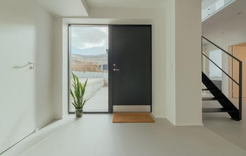 a hallway with a black door and a plant at Nyrenoveret, moderne,hyggeligt hus in Leirvík