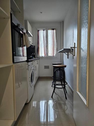 une cuisine avec une table et une machine à laver dans l'établissement appartement proche aéroport, à Nice