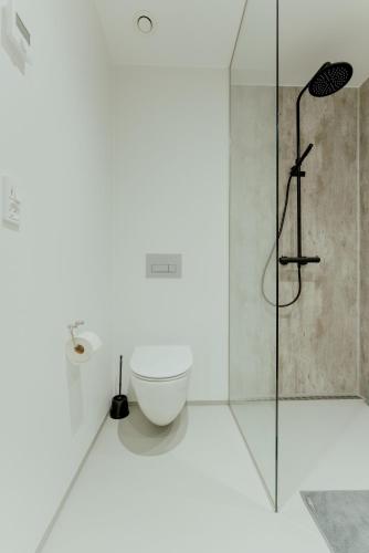 a bathroom with a toilet and a shower at Nyrenoveret, moderne,hyggeligt hus in Leirvík