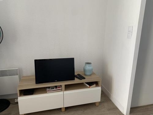 - une télévision installée au-dessus d'un centre de divertissement blanc dans l'établissement Studio rénové avec loggia, WIFI et parking privé à Hyères Port - FR-1-335-131, à Hyères