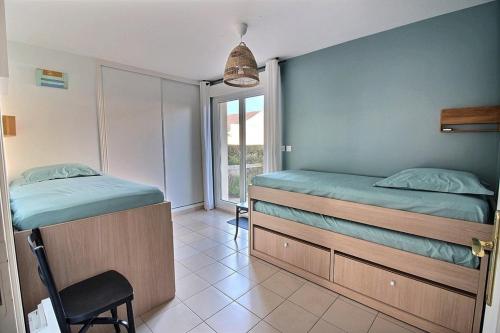 Un dormitorio con dos camas individuales y un balcón. en Annonce professionnelle. Appartement en rdc face mer, 2 chambres pour 4 à 6 personnes HARDELOT, en Hardelot-Plage