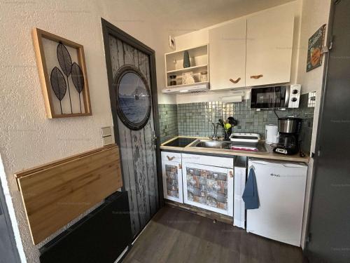 une petite cuisine avec un réfrigérateur et un évier dans l'établissement Studio avec balcon, piscine, parking privé - Narbonne Plage - FR-1-229B-102, à Narbonne