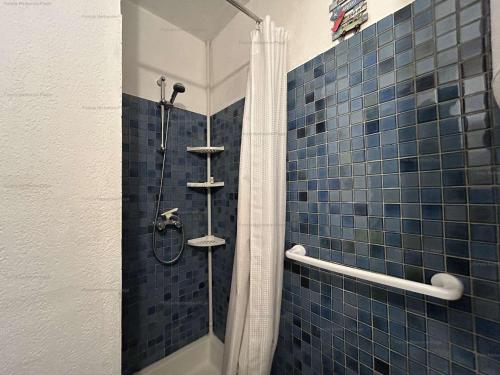 une salle de bain avec douche aux carreaux bleus dans l'établissement Studio avec balcon, piscine, parking privé - Narbonne Plage - FR-1-229B-102, à Narbonne