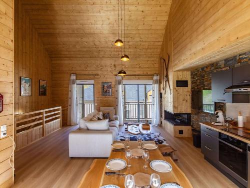 une cuisine et un salon avec une table dans une pièce dans l'établissement Lodge neuf avec grande terrasse et équipement haut de gamme - FR-1-401-292, à Cauterets