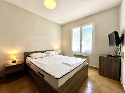 une chambre avec un lit, une fenêtre et une télévision dans l'établissement Maison St-Georges-d'Oléron avec piscine privée et véranda, 4 couchages, proche plage - FR-1-246A-312, à Saint-Georges-dʼOléron