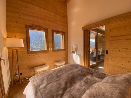 - une chambre avec un lit, 2 chaises et des fenêtres dans l'établissement Impérial A201 - Multipass inclu, à Châtel