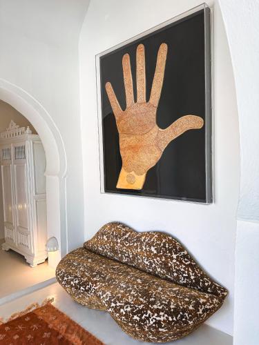 a picture of a hand hanging on a wall at Dar Fen Luxery House in Houmt Souk