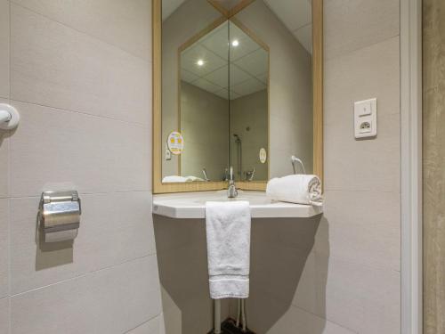 a bathroom with a sink and a mirror at Premi&egrave;re Classe Chartres Sud - Barjouville in Chartres