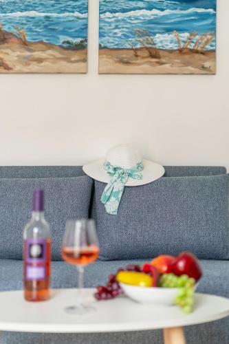 a table with a glass of wine and a bowl of fruit at Faflagos Apartments in Psari Forada