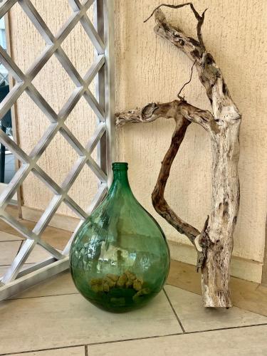 a green vase sitting on the floor next to a tree at Vila Vera Seafront Apartments in Sumartin