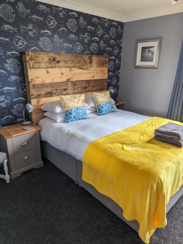 a bedroom with a large bed with a wooden headboard at Seals Bacton in Bacton