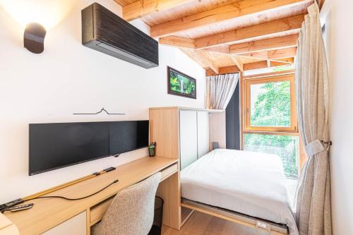 - une chambre avec un bureau, un lit et une télévision dans l'établissement GuestReady - Spacieux apt. avec cour privative, à Paris