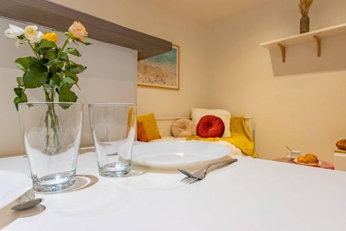 une table avec deux verres et un vase avec des fleurs dans l'établissement Le Nid Douillet - Lit King Size, à Montauban