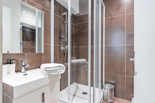 une salle de bain avec douche et lavabo dans l'établissement Le Nid Douillet - Lit King Size, à Montauban