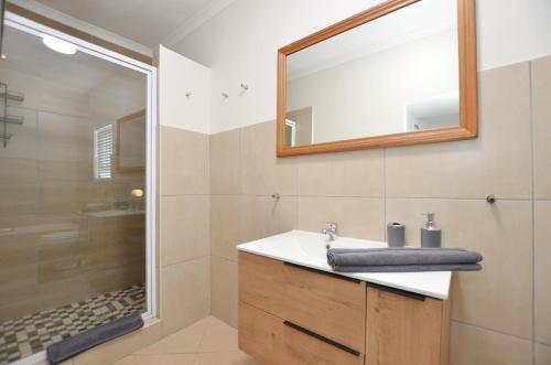 a bathroom with a sink and a mirror and a shower at Seaforever Apartment in Yzerfontein