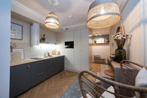 a kitchen with two pendant lights and a table at Milla Apartamenty in Zamość