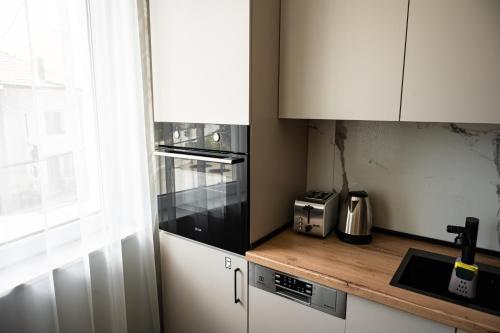 a kitchen with white cabinets and a counter top at Bitola Apartments in Bitola