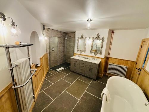 a bathroom with a tub and a sink and a shower at Sneaton Castle in Whitby