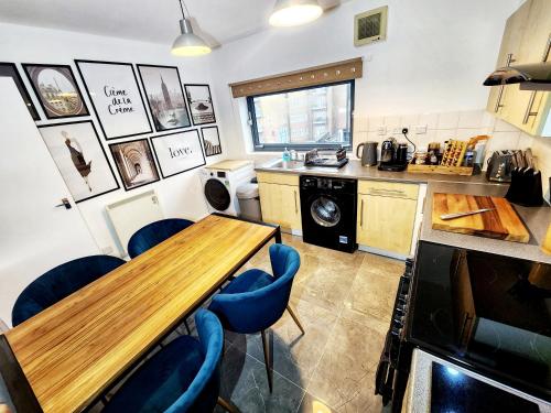 a kitchen with a wooden table and blue chairs at Brand New Flat - Canary Wharf in London