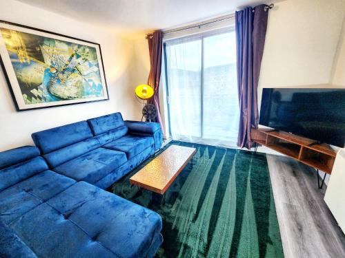 a living room with a blue couch and a television at Brand New Flat - Canary Wharf in London