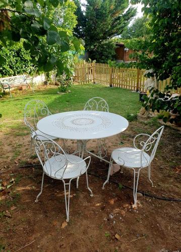 une table blanche et deux chaises assises autour d'une table dans l'établissement Location de vacances T2 non loin d'Aix et Marseille, à Pourrières