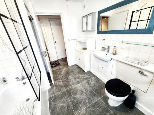 a bathroom with a toilet and a sink and a mirror at Brand New Flat - Canary Wharf in London