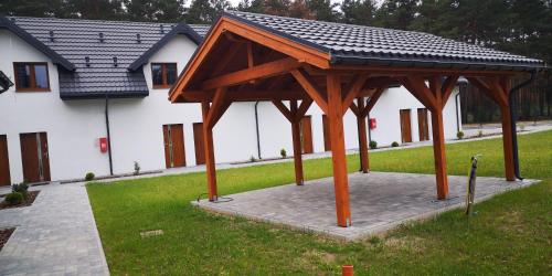 a wooden pavilion in front of a building at Extra Apartament Leśny Miodek Sielpia Wielka in Sielpia Wielka