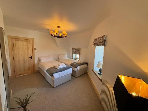 a bedroom with two beds and a tv in it at Sneaton Castle in Whitby
