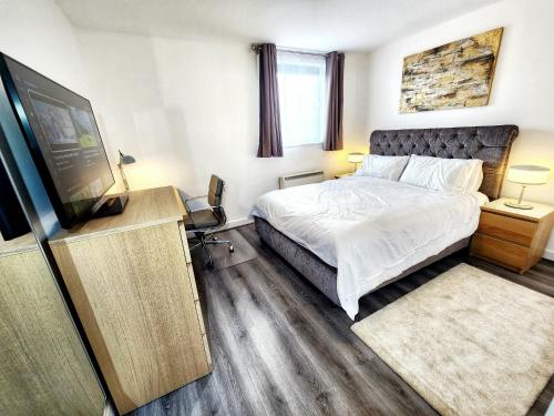 a bedroom with a bed and a flat screen tv at Brand New Flat - Canary Wharf in London