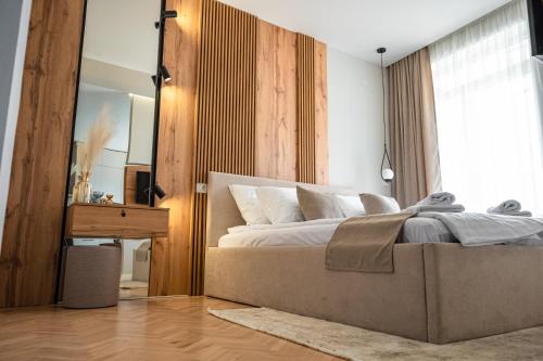 a bedroom with a large bed and a mirror at Bitola Apartments in Bitola