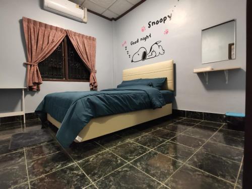 a bedroom with a bed and a sign on the wall at 11house in Betong