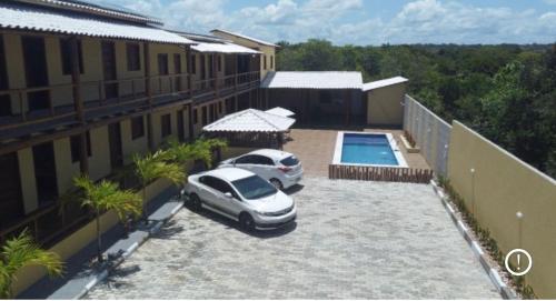 a car parked in a parking lot next to a building at Pousada Ilha de Itacimirim in Camacari