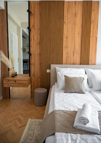 a bedroom with a large white bed with a mirror at Bitola Apartments in Bitola