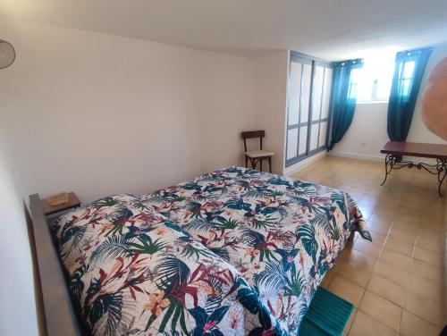 une chambre avec un lit avec un couvre-lit fleuri dans l'établissement Les Reflets du Lac, à Esparron-de-Verdon