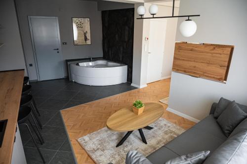 a living room with a bath tub and a table at Bitola Apartments in Bitola