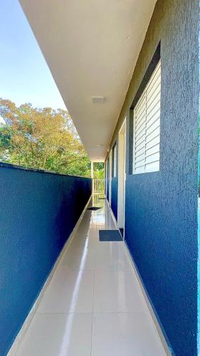 an empty hallway of a building with blue walls at Brisa mar pousada in Ubatuba