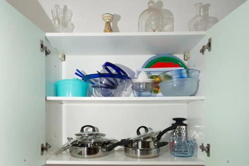 a kitchen counter with two pots and pans on shelves at Villa Anna - Bike Friendly in Buonconvento