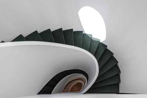 eine Wendeltreppe in einem Gebäude mit einem Spiegel in der Unterkunft Montecarmo12 - Design Boutique Hotel in Lissabon