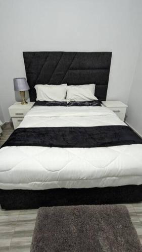 a bedroom with a large bed with a black headboard at Kumalo apartment in Lusaka