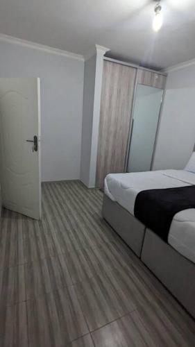 a bedroom with a bed and a door to a room at Kumalo apartment in Lusaka