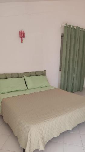 1 dormitorio con 1 cama con sábanas y cortinas verdes en Sizilien 3, en Trappeto