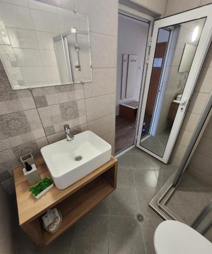 a bathroom with a white sink and a mirror at Mirana Family Hotel in Burgas City