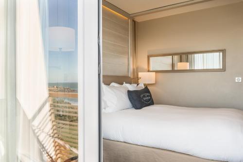 a hotel room with a bed and a window at Sofitel Quiberon Thalassa sea & spa in Quiberon